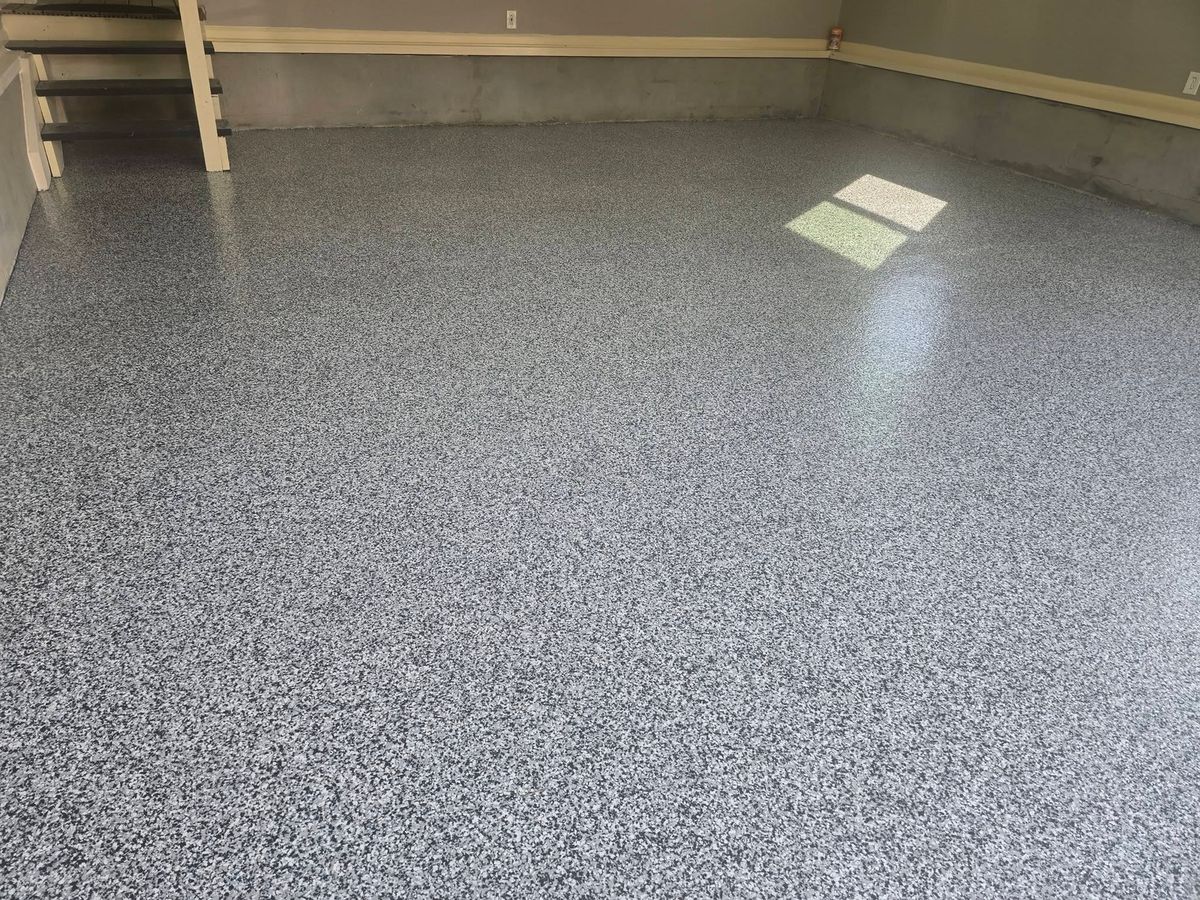 Sunlight from a window across a gray flake epoxy garage floor