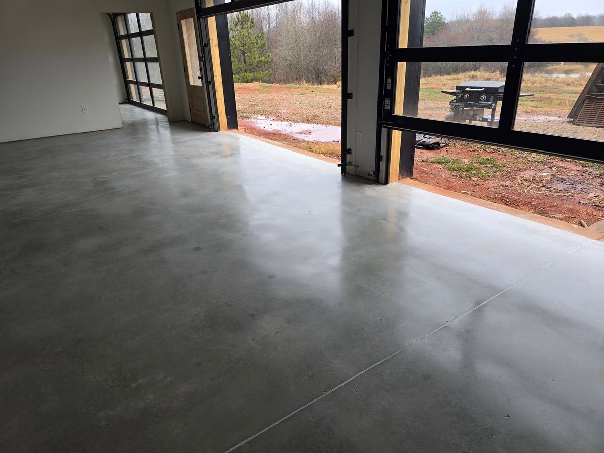 Polished garage floor with the bay doors open onto the driveway