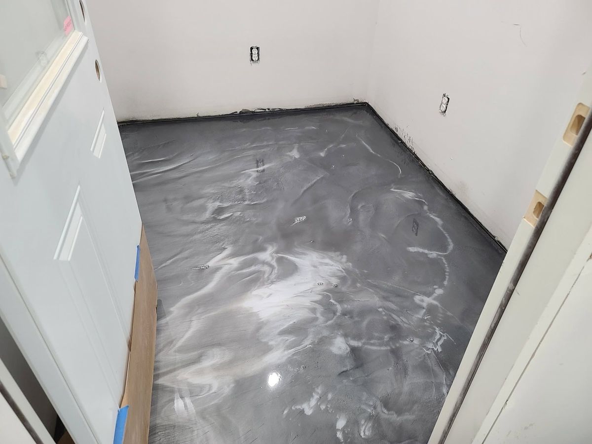 Metallic epoxy floor in a small room, gray with white veining