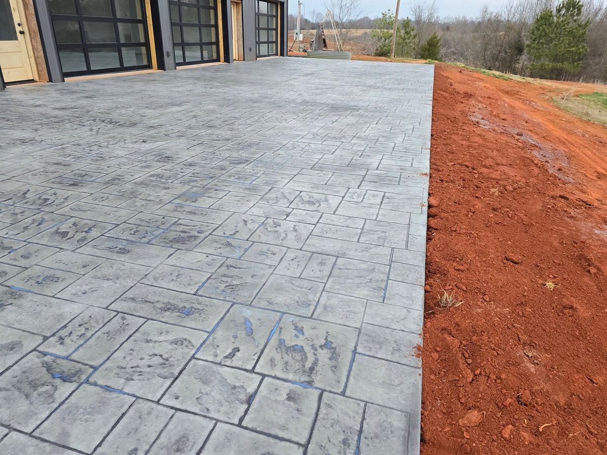 Ashlar-slate stamped driveway with graded red clay along its edge