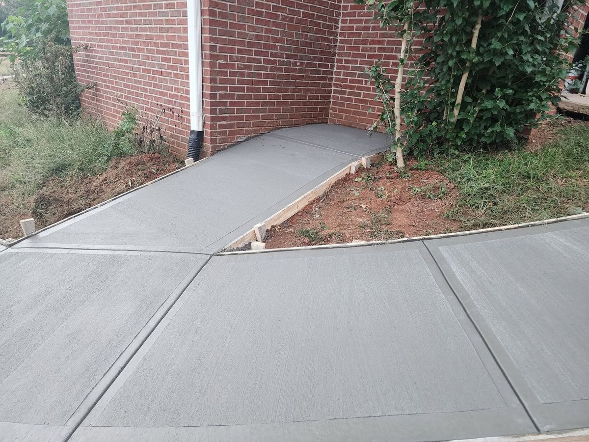 Fresh concrete driveway leading up to a brick home