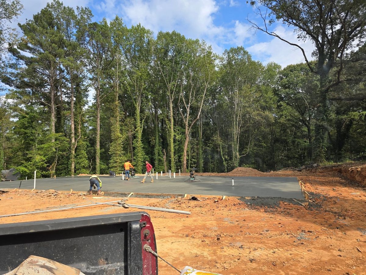 Large concrete slab being placed by the crew under the pines