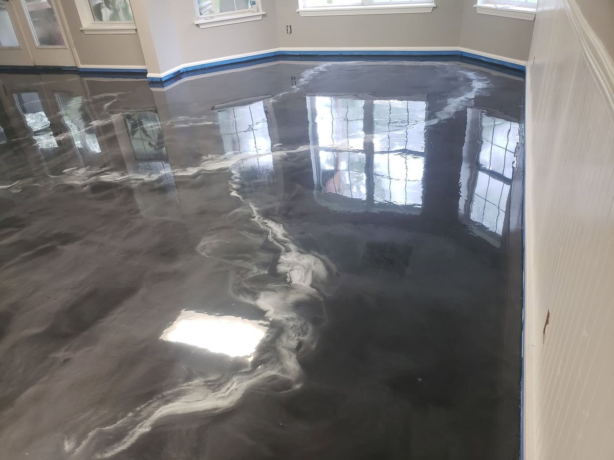 Metallic epoxy floor in a room with a bay of windows