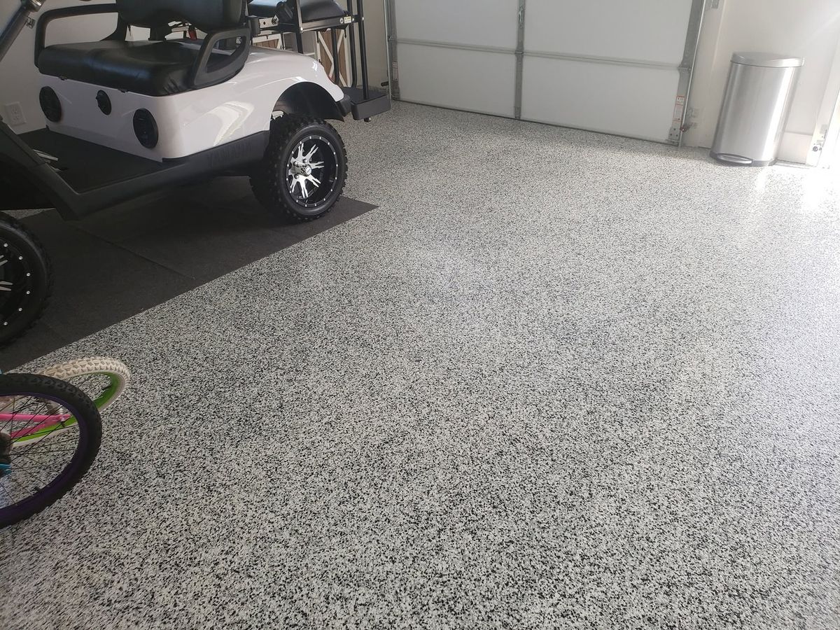 Lifted golf cart on a gray flake epoxy floor in a garage