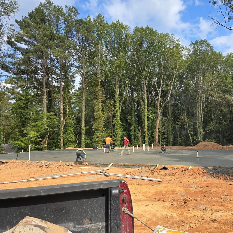 Crew spread across a large slab pour on a wooded lot