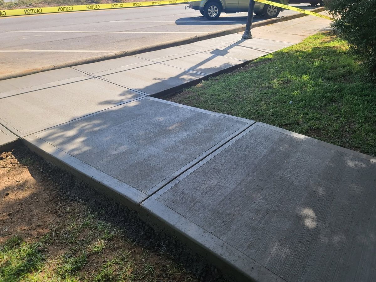 New concrete driveway apron meeting the street at the curb