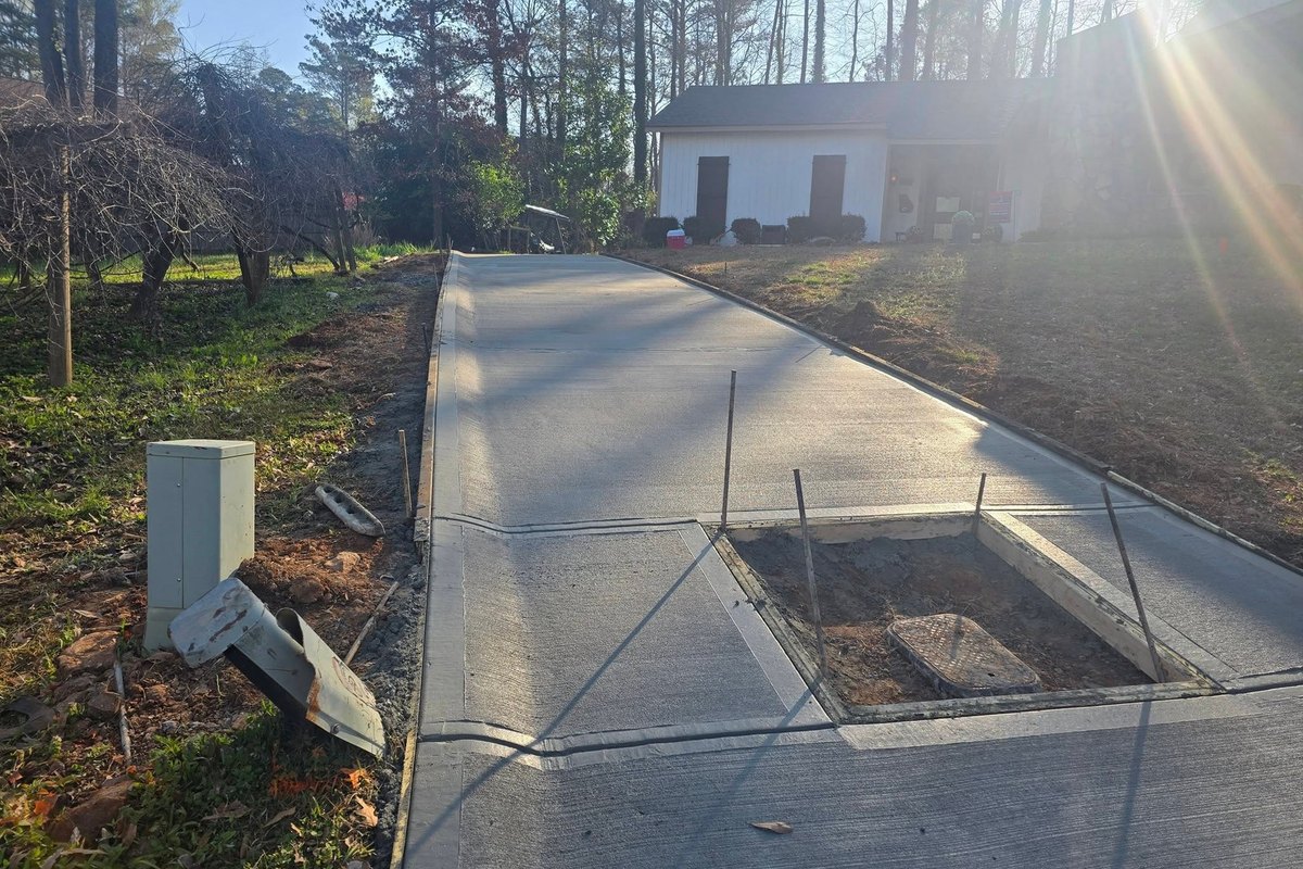 Long concrete driveway running back to a detached garage