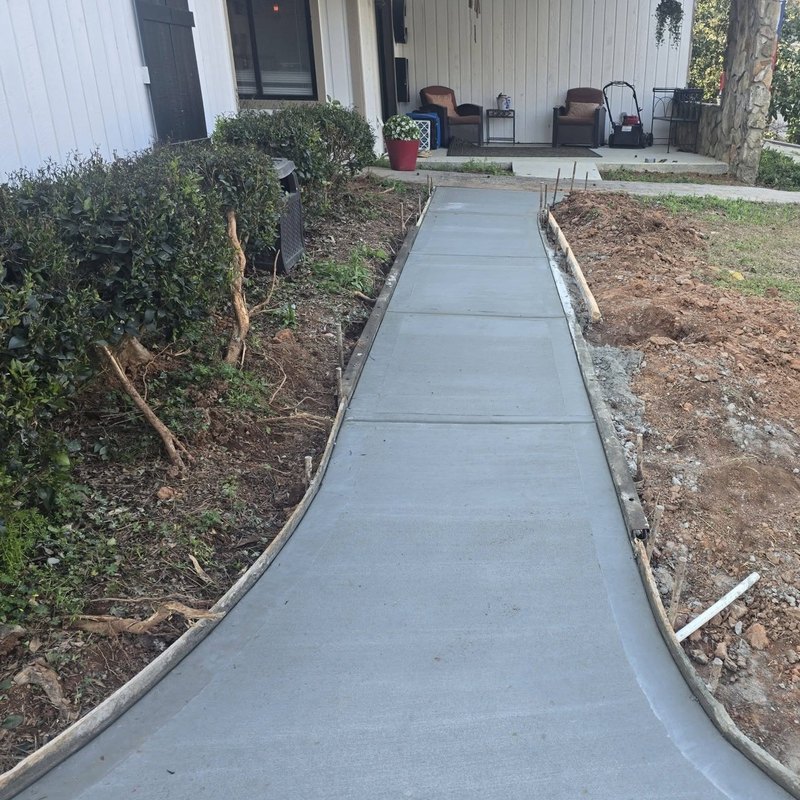 Side-yard concrete walkway running toward a covered patio