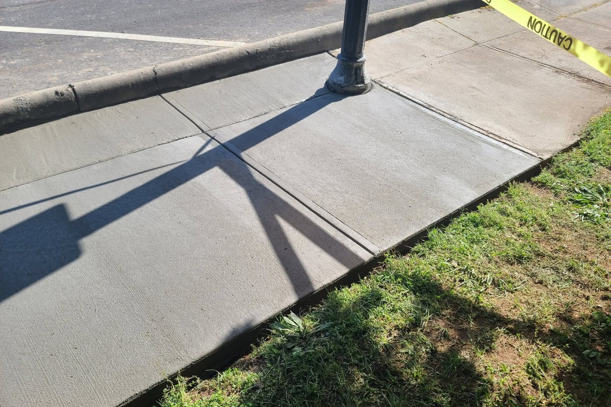 Replaced concrete sidewalk panels around a lamp post at the curb