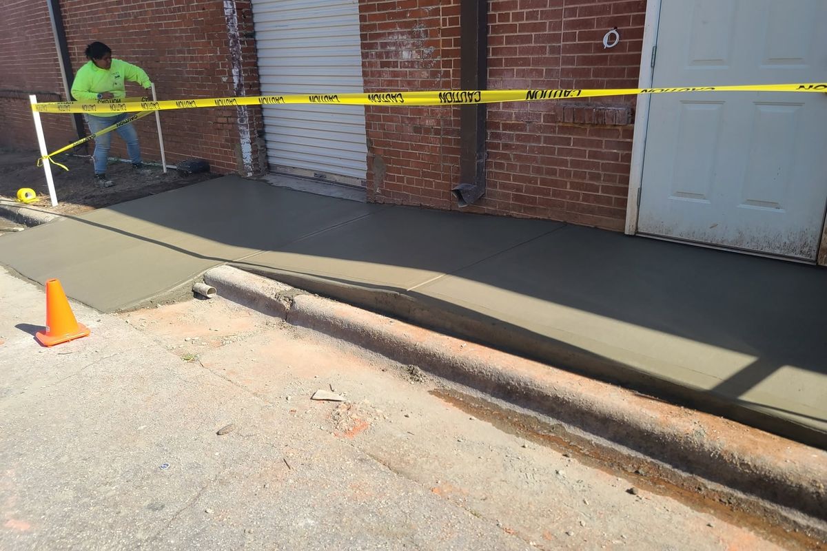 Rebuilt concrete ramp and landing at a brick building entrance