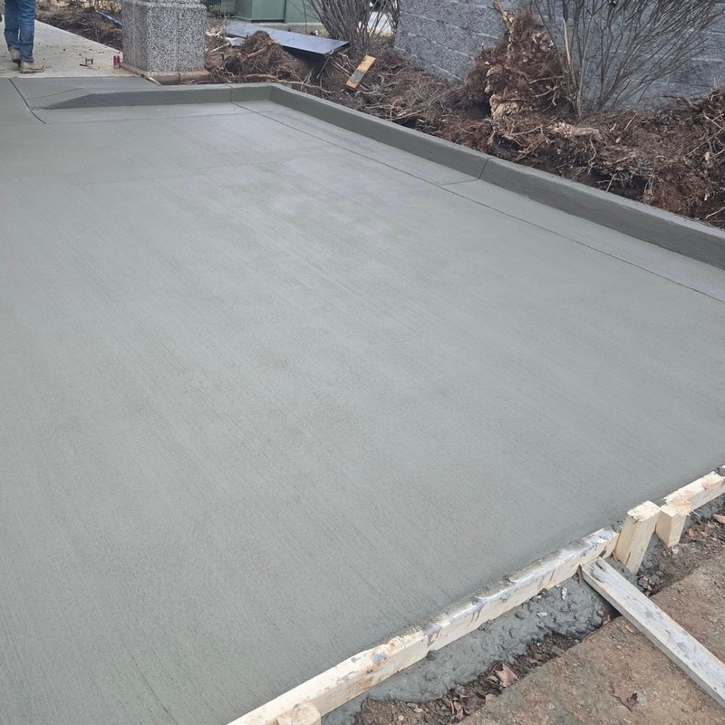 New concrete pad still in its forms on a freshly cleared lot