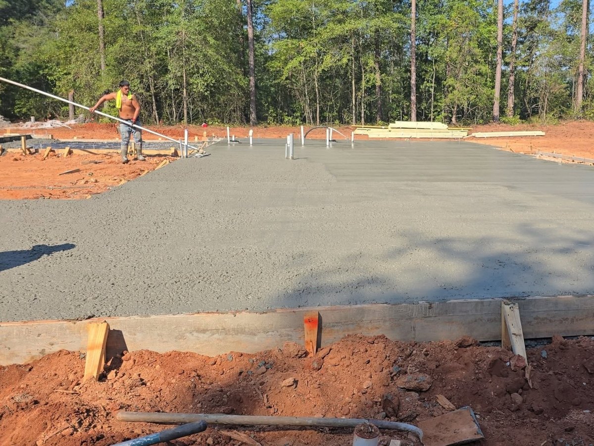 New house slab poured between the forms on a wooded lot