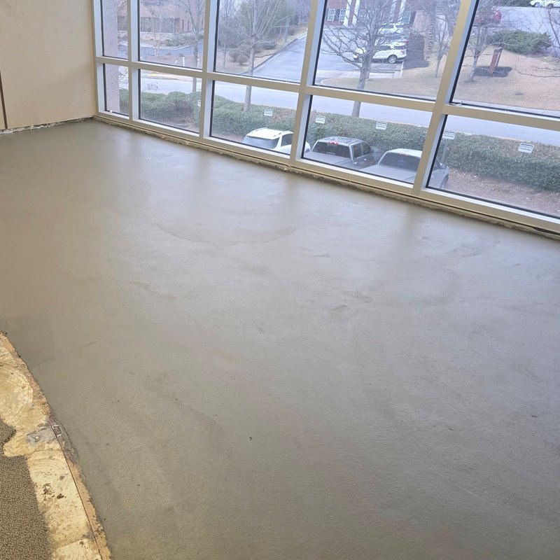 Interior concrete slab freshly finished along a window wall