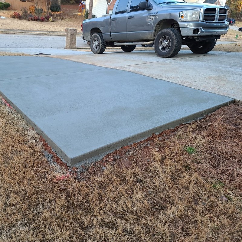 Work truck backed up to a freshly poured concrete pad