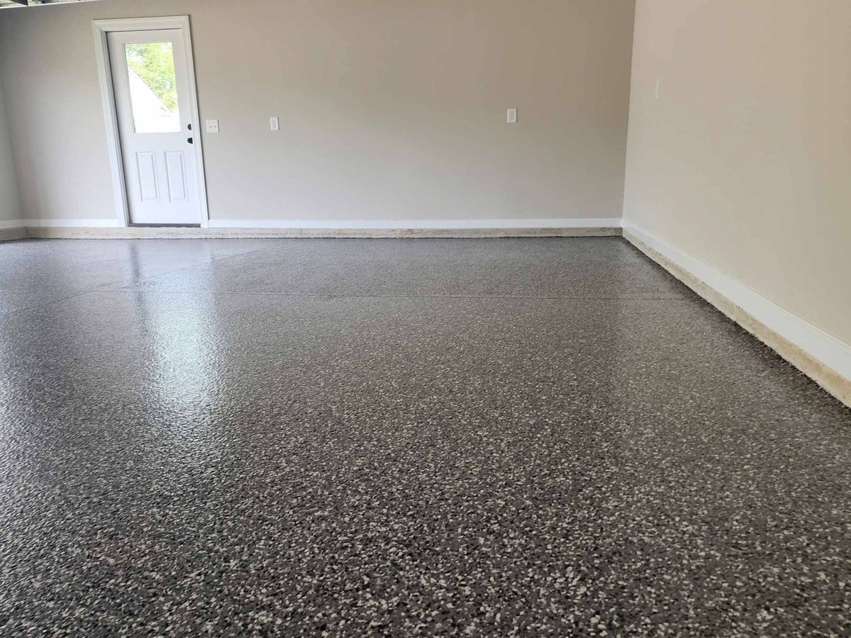 Gray flake epoxy floor with sunlight through the garage door
