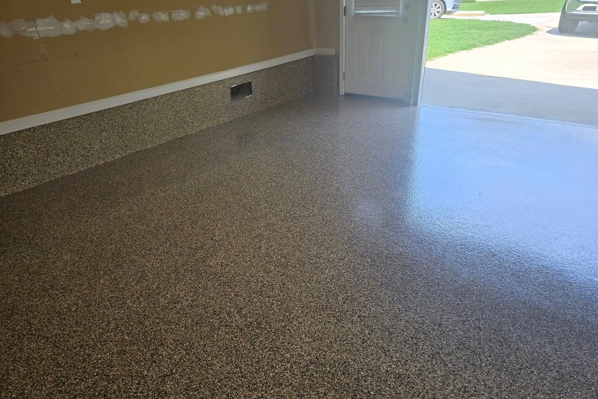 Tan flake epoxy garage floor with the entry door open