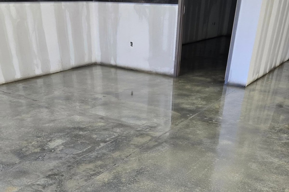 Polished concrete floor reflecting the walls of an empty room