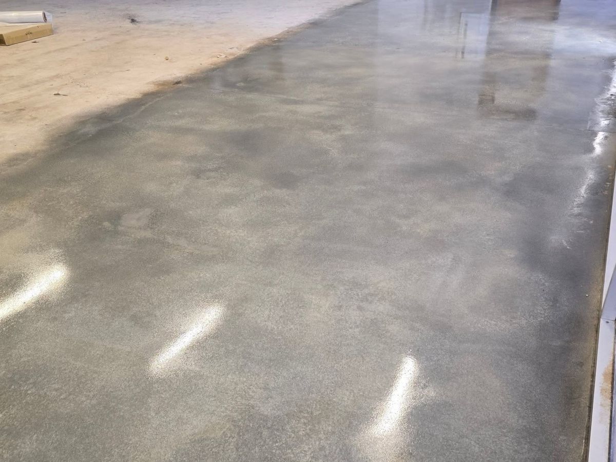 Light reflecting off a polished concrete floor across a wide room