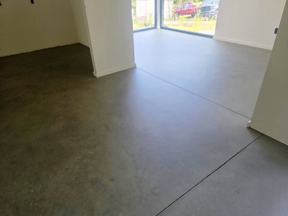 Polished concrete floor running through an open room to a glass wall