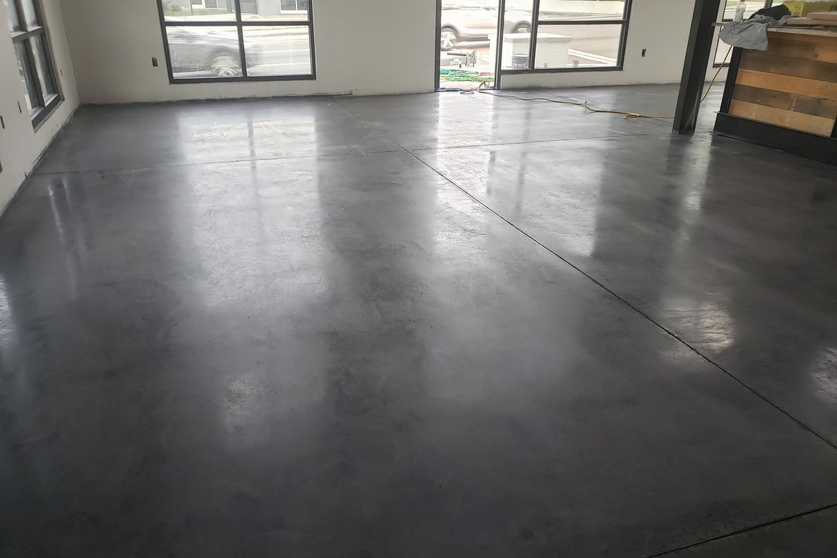 Polished concrete shop floor beside a wall of windows