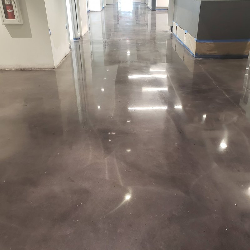 Polished concrete floor in an empty room with tall windows
