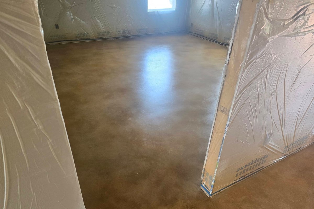 Stained concrete floor with the walls still under plastic sheeting