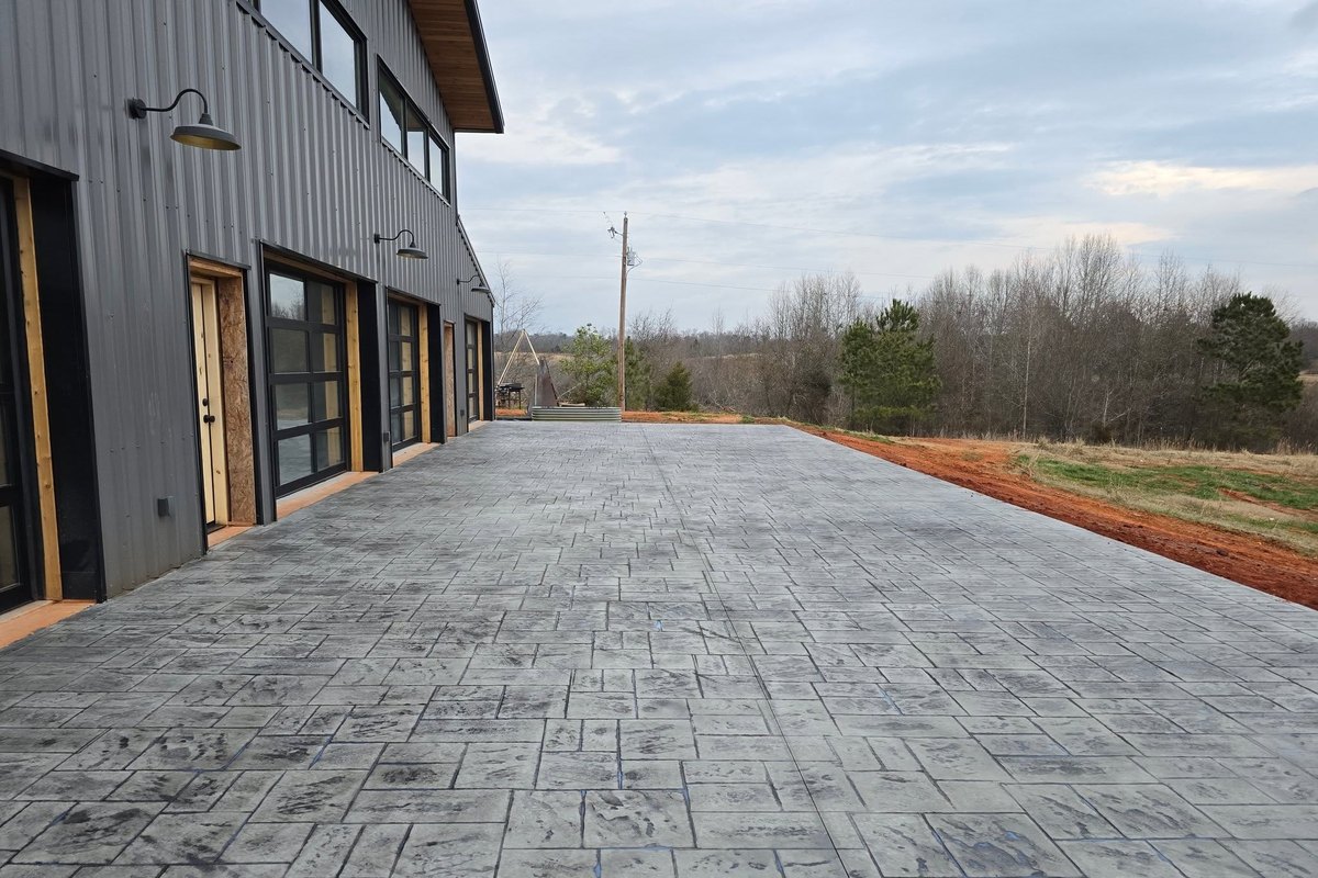 Stamped concrete driveway in front of a metal-sided building